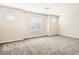 Spacious bedroom with ample natural light from multiple windows, complemented by soft carpeting and neutral tones at 10748 Wild Poppy Ave, Las Vegas, NV 89129
