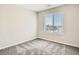 Bright bedroom with a large window offering a scenic view, complemented by neutral walls and plush carpeting at 10748 Wild Poppy Ave, Las Vegas, NV 89129