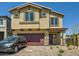 Two-story home featuring a red two-car garage and desert landscaping at 10748 Wild Poppy Ave, Las Vegas, NV 89129