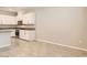Open kitchen layout showcasing white cabinets, stainless steel appliances, and easy access to the dining area at 10748 Wild Poppy Ave, Las Vegas, NV 89129