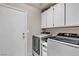 Functional laundry room featuring modern washer and dryer units, along with built-in storage cabinets at 1713 Diamond Oaks Ct, Las Vegas, NV 89117