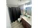 Functional bathroom featuring a dark vanity, toilet, and shower with a dark shower curtain at 1912 Nebula Dr, Las Vegas, NV 89115