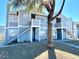 Inviting two-story apartment building with an inviting staircase entrance and a tree in the front yard at 1912 Nebula Dr, Las Vegas, NV 89115
