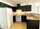 Compact kitchen featuring white appliances, dark cabinets, and neutral countertops at 1912 Nebula Dr, Las Vegas, NV 89115