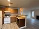 Cozy kitchen and living area featuring wood cabinets, white appliances, and a breakfast bar at 1912 Nebula Dr, Las Vegas, NV 89115
