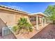 View of backyard with covered patio, desert landscaping, and air conditioning condenser at 202 Twin Creek St, Henderson, NV 89074