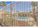 View of a refreshing community pool with mature palm trees, seen through a fence at 202 Twin Creek St, Henderson, NV 89074
