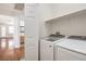 Bright laundry room featuring modern Samsung washer and dryer with a shelf above at 202 Twin Creek St, Henderson, NV 89074