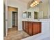 Bathroom featuring a double sink vanity, wood cabinets, soaking tub, and walk in closet at 2229 Suffron Hills Ct, Henderson, NV 89044