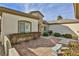 Exterior patio featuring decorative brick pavers, mature shrubs, and a small stone bench at 2229 Suffron Hills Ct, Henderson, NV 89044