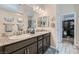 Bathroom vanity featuring double sinks, granite countertops, and decorative mirrors at 2664 Ornate Regiment St, Henderson, NV 89044