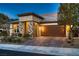 Charming home exterior with stone accents, lush landscaping, and a two-car garage at 2664 Ornate Regiment St, Henderson, NV 89044