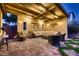 The covered patio features a cozy seating area with ample lighting for evening gatherings at 2664 Ornate Regiment St, Henderson, NV 89044