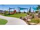 Community playground with shade canopies, slide, and other play structures surrounded by landscaping at 2664 Ornate Regiment St, Henderson, NV 89044