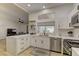 Modern kitchen featuring white cabinetry, stainless steel appliances, and a stylish breakfast bar at 2739 Darby Falls Dr, Las Vegas, NV 89134