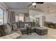 Spacious living room with modern sectional sofa, hardwood flooring, and access to the kitchen at 2739 Darby Falls Dr, Las Vegas, NV 89134