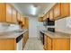 Galley kitchen features oak cabinetry, neutral countertops, and modern appliances at 3318 N Decatur Blvd # 2138, Las Vegas, NV 89130