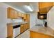 Galley kitchen features oak cabinetry, neutral countertops, and modern appliances at 3318 N Decatur Blvd # 2138, Las Vegas, NV 89130