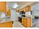 Well-lit kitchen with wood cabinets, granite countertops, and black appliances at 3318 N Decatur Blvd # 2138, Las Vegas, NV 89130