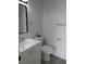 Bathroom featuring white vanity, sink, toilet, mirror, and towel racks, all complemented by wood-look flooring at 3484 Nightflower Ln # 2, Las Vegas, NV 89121