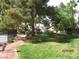 Well-maintained lawn with mature trees and charming walkways create an inviting outdoor space at 3484 Nightflower Ln # 2, Las Vegas, NV 89121