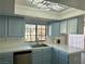 Kitchen featuring a stainless steel sink, white countertops, light blue cabinets, and a window overlooking the yard at 3484 Nightflower Ln # 2, Las Vegas, NV 89121
