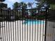 Community pool with lounge chairs and a slide, enclosed by a black metal fence at 3484 Nightflower Ln # 2, Las Vegas, NV 89121