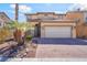 Inviting two-story home featuring a tile roof, desert landscaping, and a brick-paved driveway leading to a two-car garage at 3517 Colby Creek Ave, North Las Vegas, NV 89081