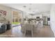 Open concept kitchen and dining area with white cabinets, stainless steel appliances, and a view of the backyard at 3517 Colby Creek Ave, North Las Vegas, NV 89081