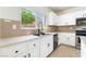 Bright kitchen features white cabinets, black hardware, stainless appliances, and a view to the backyard at 3517 Colby Creek Ave, North Las Vegas, NV 89081