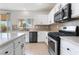 Well-lit kitchen featuring stainless steel appliances, white cabinetry, and a view of the outdoor patio at 3517 Colby Creek Ave, North Las Vegas, NV 89081