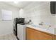 Bright laundry room features a washing machine, dryer, sink, and storage, offering convenience and organization at 3517 Colby Creek Ave, North Las Vegas, NV 89081