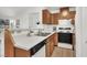 Kitchen features a dual basin sink, white countertop, and wood cabinets with black and white appliances at 3609 Melonies Dr # 93, Las Vegas, NV 89103