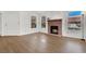 Living room with wood laminate flooring, a brick fireplace, and light streaming through the many windows at 3609 Melonies Dr # 93, Las Vegas, NV 89103