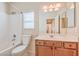 Well-maintained bathroom featuring a shower-tub combo, vanity with cabinets, and decorative light fixture at 4399 Luciano Ave, Pahrump, NV 89061