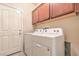 Functional laundry room with a washer, dryer, and overhead cabinets for storage, offering convenience and organization at 4399 Luciano Ave, Pahrump, NV 89061