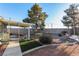 Serene backyard featuring desert landscaping, mature trees, and a covered patio at 4405 Testarossa Ln, North Las Vegas, NV 89081