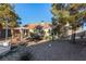 Private backyard with desert landscaping, mature trees, a gazebo, and a charming patio area at 4405 Testarossa Ln, North Las Vegas, NV 89081