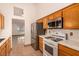 Well-lit kitchen with stainless steel appliances, oak cabinets, and tile flooring at 4405 Testarossa Ln, North Las Vegas, NV 89081