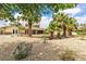 Charming home featuring a gravel backyard with mature palm trees and a covered patio at 4678 Saddle Pl, Las Vegas, NV 89119