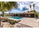 Refreshing pool area with a brick home exterior, a covered patio, and mature landscaping at 4678 Saddle Pl, Las Vegas, NV 89119