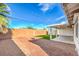 Expansive backyard with a brick wall, gravel, and a covered patio area at 5200 Longridge Ave, Las Vegas, NV 89146