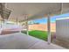 Covered patio area with a fan, overlooking a green lawn and gravel in the backyard at 5200 Longridge Ave, Las Vegas, NV 89146