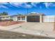 Charming single-story home with a large driveway and a modern black garage door at 5200 Longridge Ave, Las Vegas, NV 89146