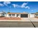 Charming single-story home with a well-manicured yard and black garage door at 5200 Longridge Ave, Las Vegas, NV 89146