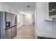 Open kitchen view leads to living area with stainless steel fridge and matching floors at 5200 Longridge Ave, Las Vegas, NV 89146