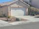 Exterior shot of a house with a two-car garage and desert landscaping in the front yard at 5404 Walcott Dr, Las Vegas, NV 89118