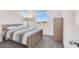 Brightly lit bedroom with natural wood furnishings, neutral colored carpet, and a view through the window at 5609 Steampunk St, Las Vegas, NV 89118