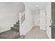 Bright entryway with a carpeted staircase, neutral color palette, and tile flooring leading to various rooms at 5609 Steampunk St, Las Vegas, NV 89118