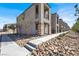 New townhome showcasing stone accents, a private balcony, and desert landscaping for low maintenance living at 5609 Steampunk St, Las Vegas, NV 89118